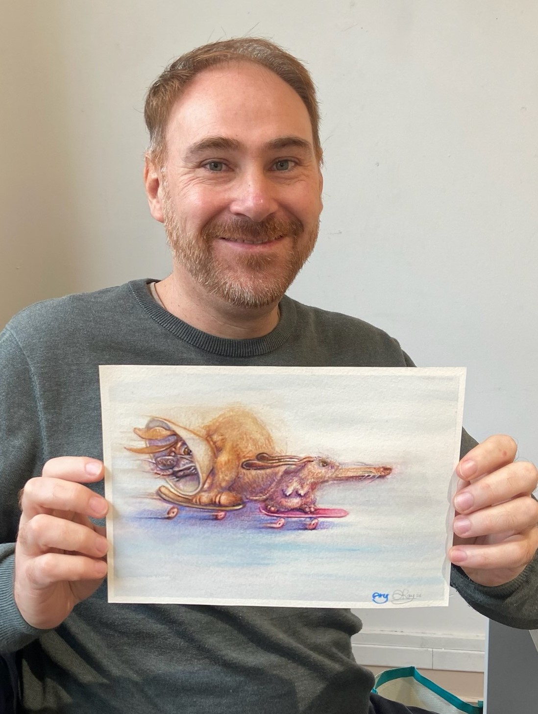 adrien-ray-artiste-illustrateur Photo de Adrien Ray tenant une de ses illustrations